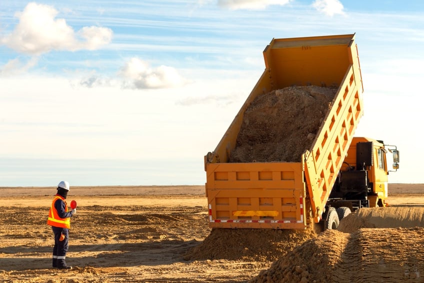 dump truck tipping dirt on an open construction site