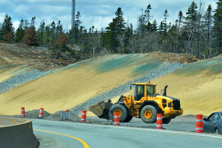 Hydroseeding completed on a hillside near a road