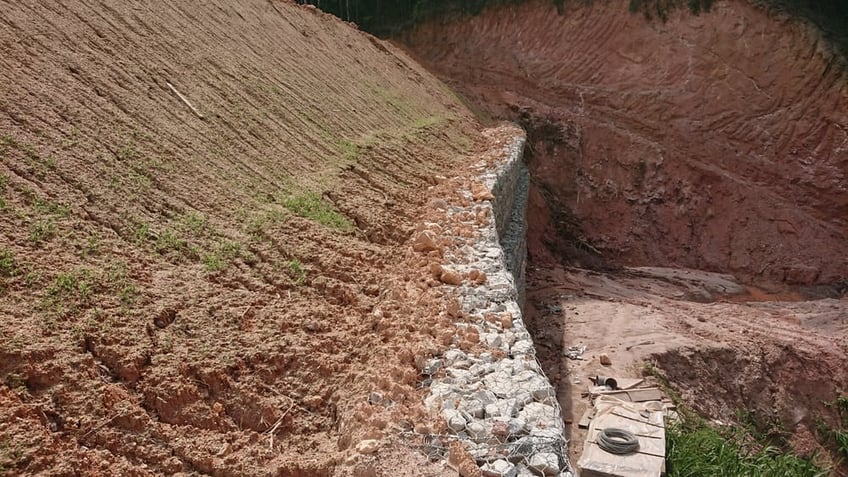 Retaining wall on a hillside with seeds beginning to grow from hydroseeding