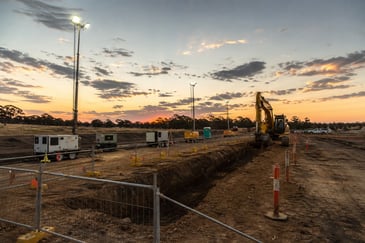 Regional civil construction site near Bendigo with trenching, lighting towers and multiple portable generators supplying temporary power.