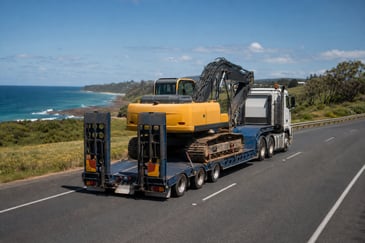 Low loader transporting an excavator along a Sunshine Coast highway