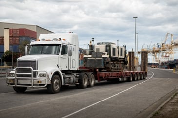 Prime mover hauling machinery on a low loader through Newcastle’s industrial precinct