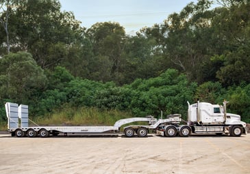 Prime mover and low loader transporting an excavator near Brisbane 